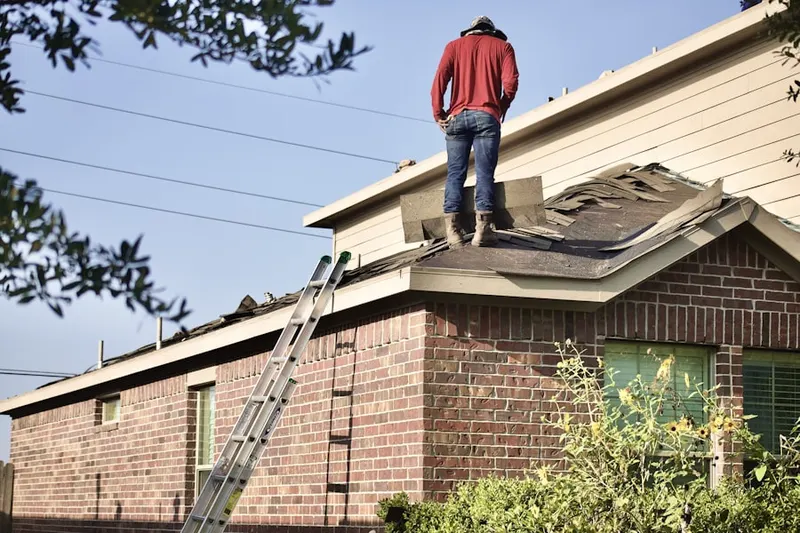 Professional roofer working on a residential roof in Mexia
